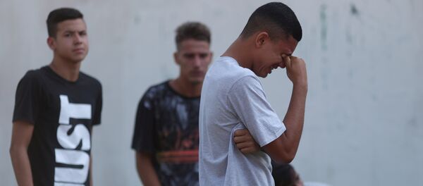Un jóven llora tras el incendio en un club de fútbol en Río de Janeiro - Sputnik Mundo