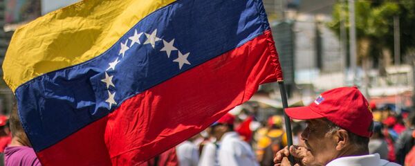 Un hombre con la bandera de Venezuela - Sputnik Mundo