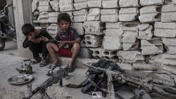 Niños miran en armas incautadas a los terroristas de ISIS en Irak - Sputnik Mundo