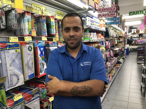 Cristian es empleado de una papelería en Buenos Aires: aún con descuentos, no le es fácil comprar los materiales escolares para su hijo - Sputnik Mundo