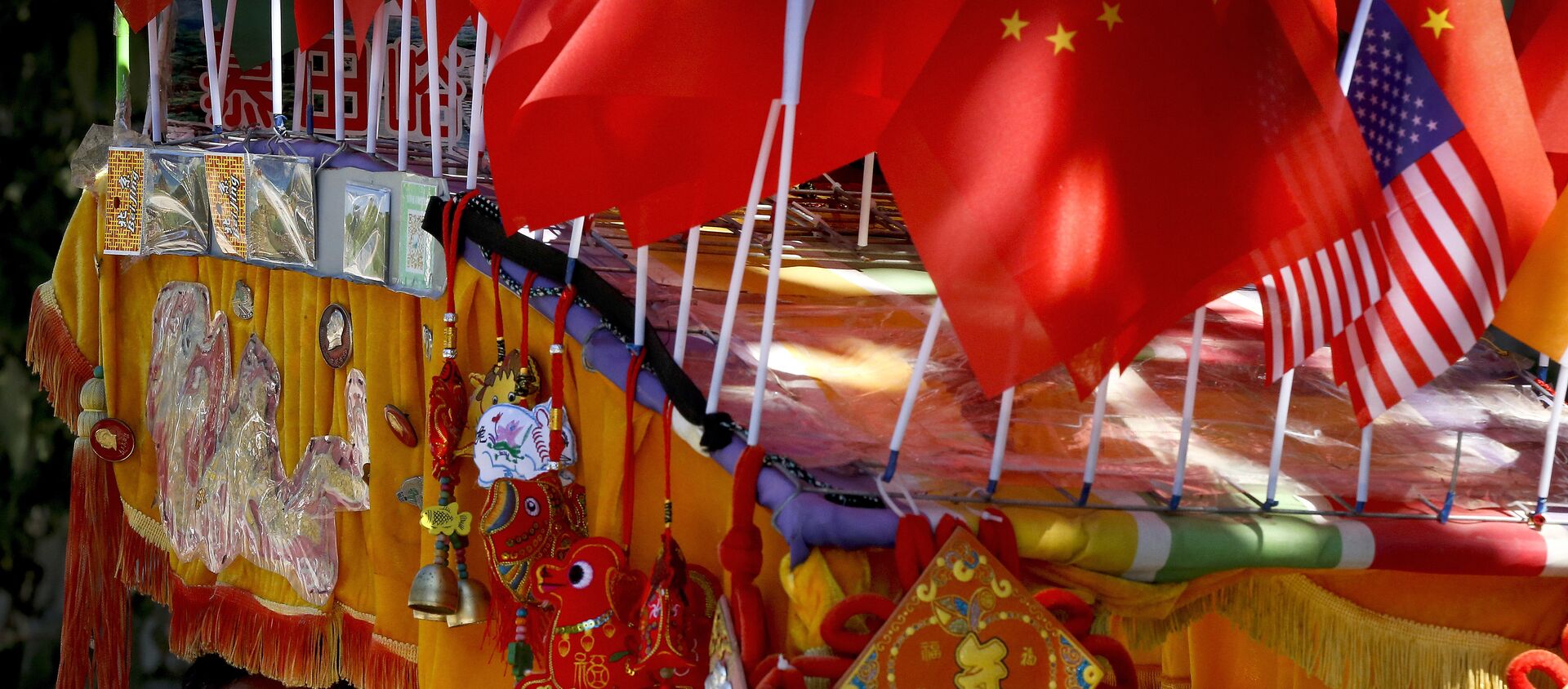 Un conductor mira desde su trishaw decorado con una bandera americana y una china en Pekín - Sputnik Mundo, 1920, 02.11.2020