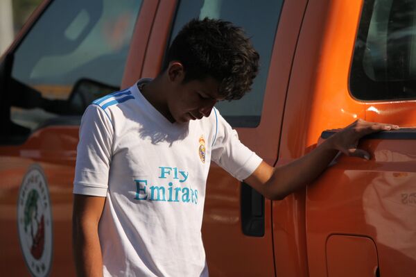 Migrante frente a una patrulla del grupo Beta del Instituto Nacional de Migraciones en el estadio Palillo, de la Ciudad de México - Sputnik Mundo