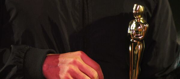 Vecino de la colonia Roma carga una estatuilla de los premios Oscar. Vecino de la colonia Roma carga una estatuilla de los premios Oscar. - Sputnik Mundo