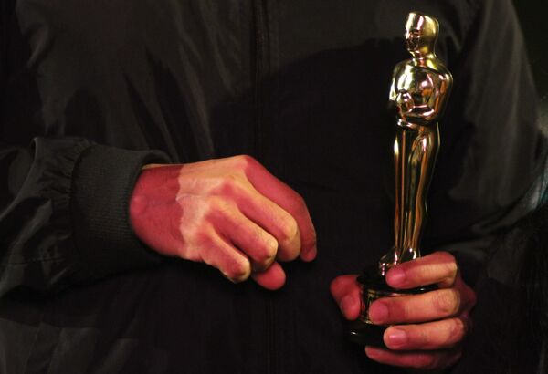 Vecino de la colonia Roma carga una estatuilla de los premios Oscar. - Sputnik Mundo