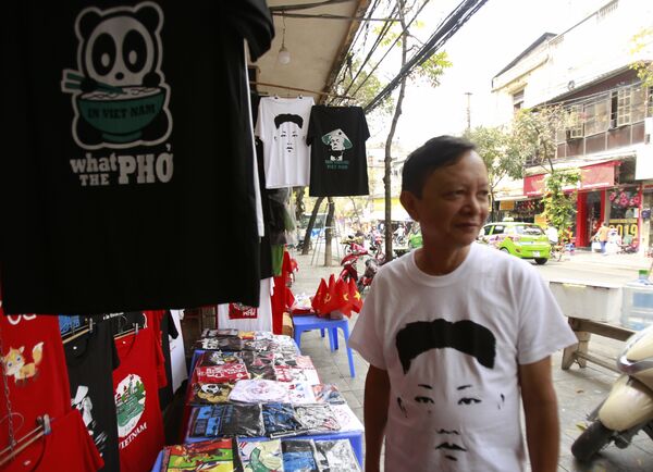 Truong Thanh Duc con una camiseta del líder norcoreano Kim Jong-un en su tienda ubicada del centro de Hanoi - Sputnik Mundo