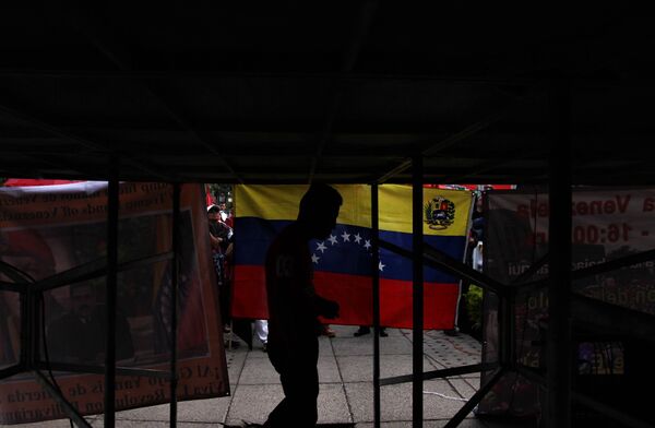 Joven pasa frente a la bandera venezolana durante el mitin ante la Embajada estadounidense en Ciudad de México Joven pasa frente a la bandera venezolana durante el mitin ante la Embajada estadounidense en Ciudad de México - Sputnik Mundo