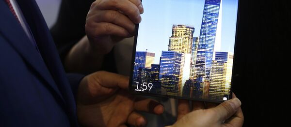 Un hombre sostiene un Mate X de Huawei durante el Congreso Mundial de Móviles - Sputnik Mundo