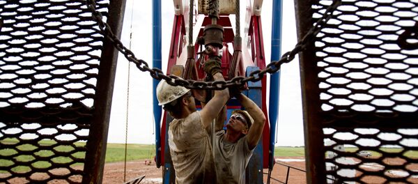 Dos empleados trabajan en una grúa petrolera en EEUU - Sputnik Mundo