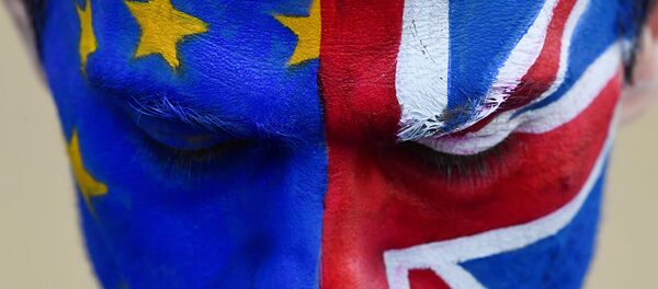 Un hombre con la cara pitada con las banderas de la UE y el Reino Unido - Sputnik Mundo