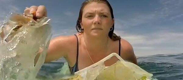 El triste vídeo de una surfista recogiendo basura del océano - Sputnik Mundo