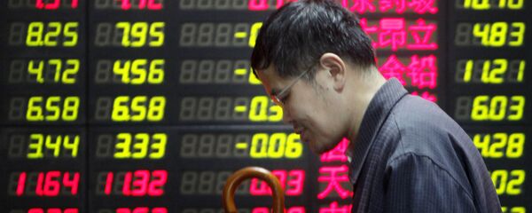 Un hombre cerca de una pantalla con precios en Shanghái - Sputnik Mundo