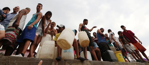 Venezolanos rellenan botellas de agua en Caracas - Sputnik Mundo
