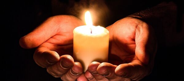 Manos sosteniendo una vela en una vigilia - Sputnik Mundo
