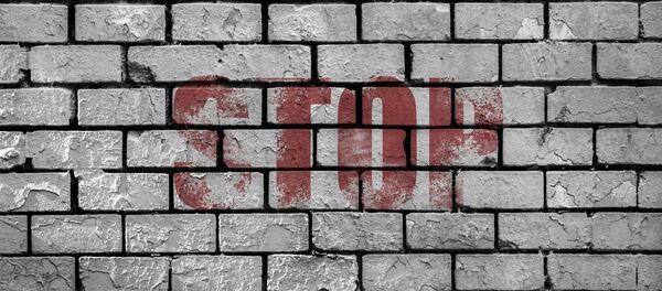 Una pared de ladrillos con palabra 'stop' - Sputnik Mundo