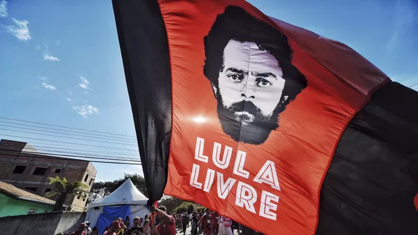 Un apoyador del expresidente de Brasil, Luiz Inácio Lula da Silva, ondea una bandera con la imagen de da Silva y un mensaje que dice Lula libre