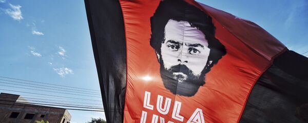Un apoyador del expresidente de Brasil, Luiz Inácio Lula da Silva, ondea una bandera con la imagen de da Silva y un mensaje que dice Lula libre Un apoyador del expresidente de Brasil, Luiz Inácio Lula da Silva, ondea una bandera con la imagen de da Silva y un mensaje que dice Lula libre - Sputnik Mundo