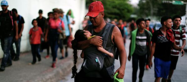 Hondureños que forman parte de una caravana de inmigrantes que se dirige a Estados Unidos caminan por Tapachula, México - Sputnik Mundo