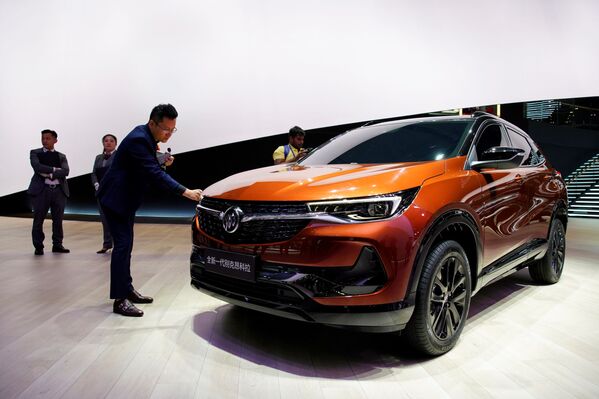 Мужчина дотрагивается до автомобиля Buick Encore на Шанхайском международном автосалоне - Sputnik Mundo