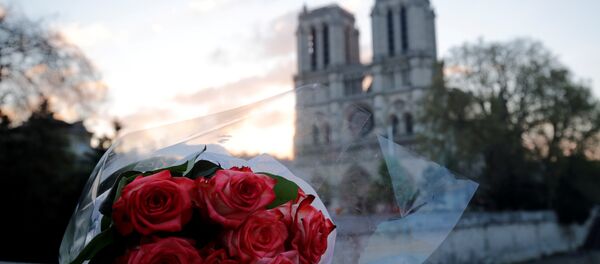 Un ramo de flores cerca de la catedral parisina de Notre Dame - Sputnik Mundo