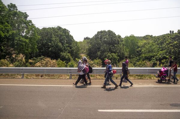 Miembros de la caravana migrante caminan sobre la carretera México 200, rumbo al norte del país, Tapachula, Chiapas, México - Sputnik Mundo