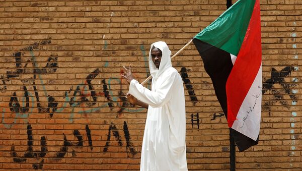 Un hombre con la bandera de Sudán - Sputnik Mundo