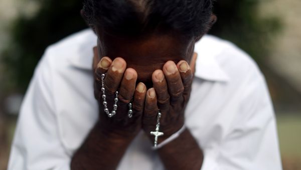Un hombre se lamenta frente a la tumba de una víctima de los ataques en Sri Lanka Un hombre se lamenta frente a la tumba de una víctima de los ataques en Sri Lanka - Sputnik Mundo