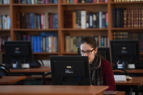 Una chica usa un ordenador en una biblioteca - Sputnik Mundo