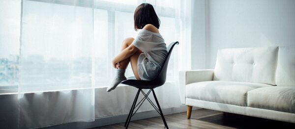 Una mujer mira por la ventana  - Sputnik Mundo