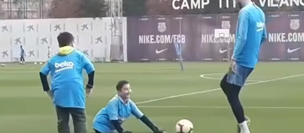 Un sueño hecho realidad: un niño sin piernas juega al fútbol con Piqué y Messi - Sputnik Mundo