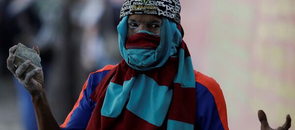 Un manifestante con una piedra en la mano en las calles de Caracas, Venezuela - Sputnik Mundo