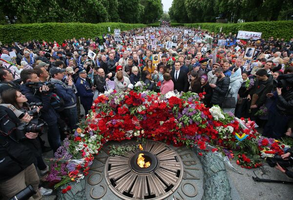 El Regimiento Inmortal deja flores en el fuego eterno del parque de la Victoria en Kiev - Sputnik Mundo