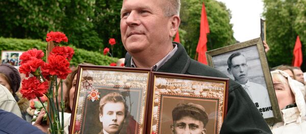 Las celebraciones del Día de la Victoria en Ucrania, un participante de la marcha Regimiento Inmortal en Kiev - Sputnik Mundo