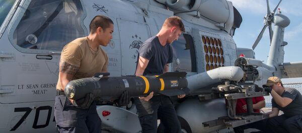 Los militares estadounidenses instalan un misil Hellfire en un helicóptero Los militares estadounidenses instalan un misil Hellfire en un helicóptero - Sputnik Mundo