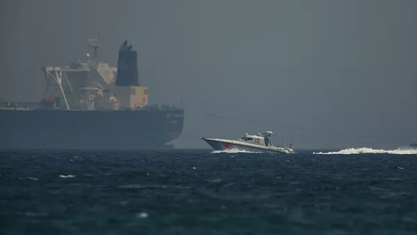 Un barco petrolero y un buque de la guardia costera emiratí - Sputnik Mundo