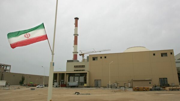 La bandera de Irán junto a la planta nuclear de Bushehr  - Sputnik Mundo