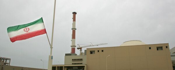 La bandera de Irán junto a la planta nuclear de Bushehr - Sputnik Mundo