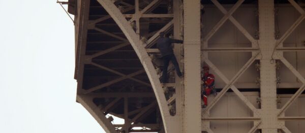 Un hombre intenta escalar la Torre Eiffel  - Sputnik Mundo