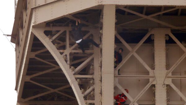 Un hombre intenta escalar la Torre Eiffel - Sputnik Mundo