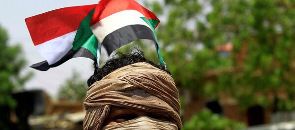 Un manifestantes con la bandera de Sudán (archivo) Un manifestantes con la bandera de Sudán (archivo) - Sputnik Mundo
