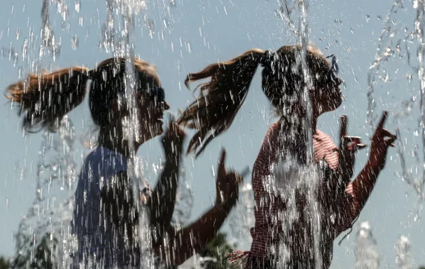 Unas mujeres se refrescan en una fuente en un caluroso día de verano en el centro de Moscú. Unas mujeres se refrescan en una fuente en un caluroso día de verano en el centro de Moscú. - Sputnik Mundo