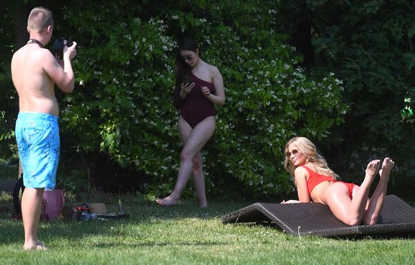 Unos jóvenes toman el sol en el Parque Gorki. Unos jóvenes toman el sol en el Parque Gorki. - Sputnik Mundo
