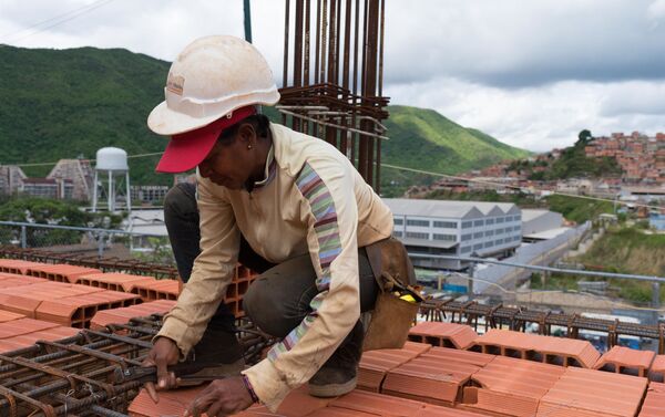 Una mujer en la construcción de los edificios que conformarán el complejo urbanístico llamado 'Jorge Rodríguez Padre', que cuenta con el apoyo financiero del Gobierno y es construido por los que serán sus propietarios 80% mujeres Una mujer en la construcción de los edificios que conformarán el complejo urbanístico llamado 'Jorge Rodríguez Padre', que cuenta con el apoyo financiero del Gobierno y es construido por los que serán sus propietarios 80% mujeres - Sputnik Mundo