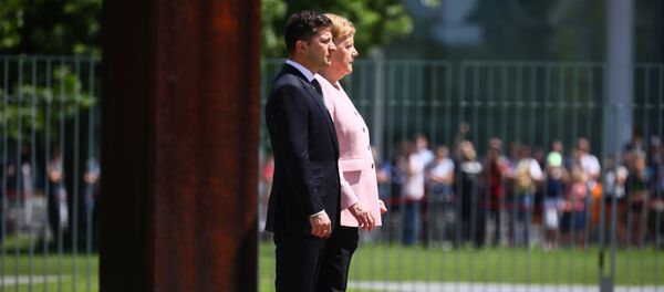 La canciller alemana, Angela Merkel, y el presidente ucraniano, Volodímir Zelenski, escuchan himnos nacionales - Sputnik Mundo