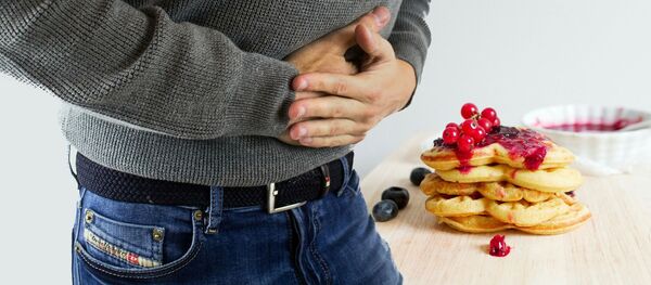 Un hombre sostiene manos sobre su estómago - Sputnik Mundo