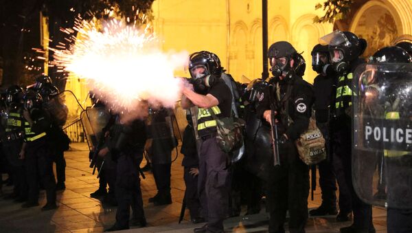 Un policía dispara durante las protestas en Tiflis, Georgia - Sputnik Mundo