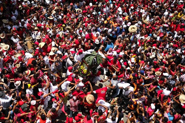 Vista general de la estatuilla de San Juan siendo paseada entre cientos de devotos durante la celebración del Día de San Juan Bautista en Curiepe. - Sputnik Mundo