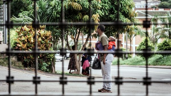 Una mujer sudafricana con su niño en busca de refugio (imagen referencial) - Sputnik Mundo