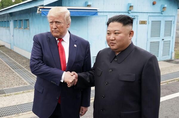 Donald Trump y Kim Jong-un se saludan en la Zona desmilitarizada de Corea - Sputnik Mundo