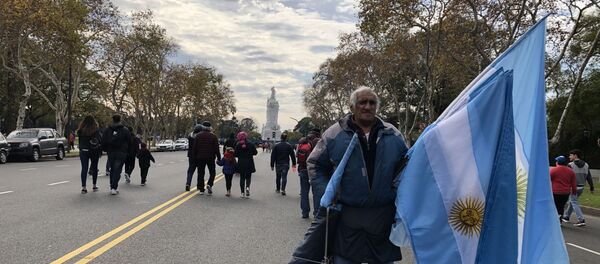 Un hombre vende banderas en la Avenida Libertador en el Día de la Independencia de Argentina Un hombre vende banderas en la Avenida Libertador en el Día de la Independencia de Argentina - Sputnik Mundo