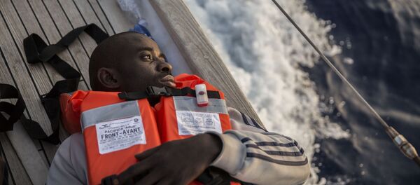 Un migrante a bordo de un barco de la ONG Mediterranea Saving Humans que navega cerca de las costas de la italiana de Lampedusa - Sputnik Mundo